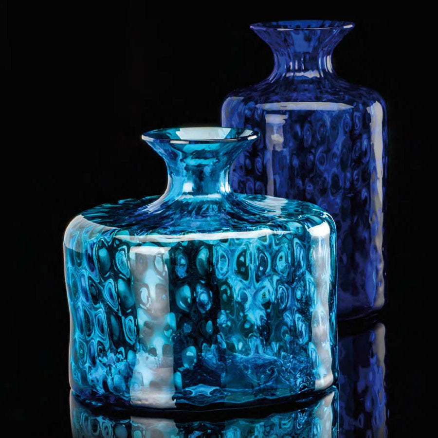Two blue glass vases with a textured surface on a black background